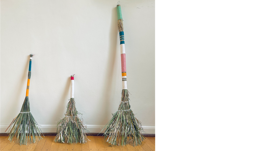 Photo of three handmade brooms with colorful handles