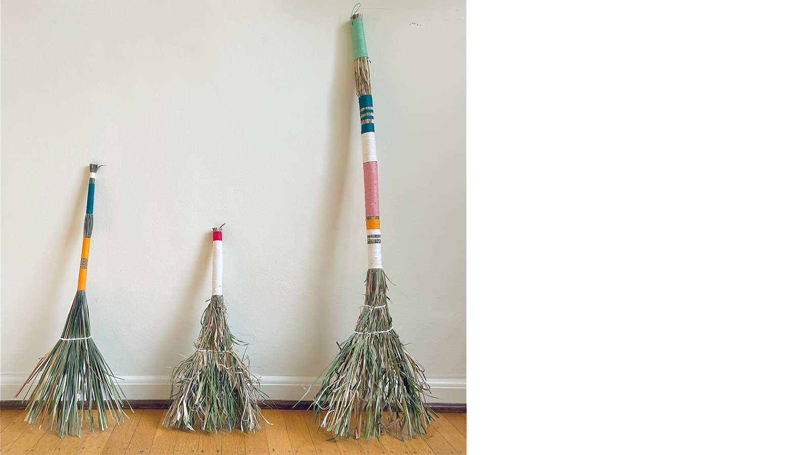 Photo of three handmade brooms with colorful handles